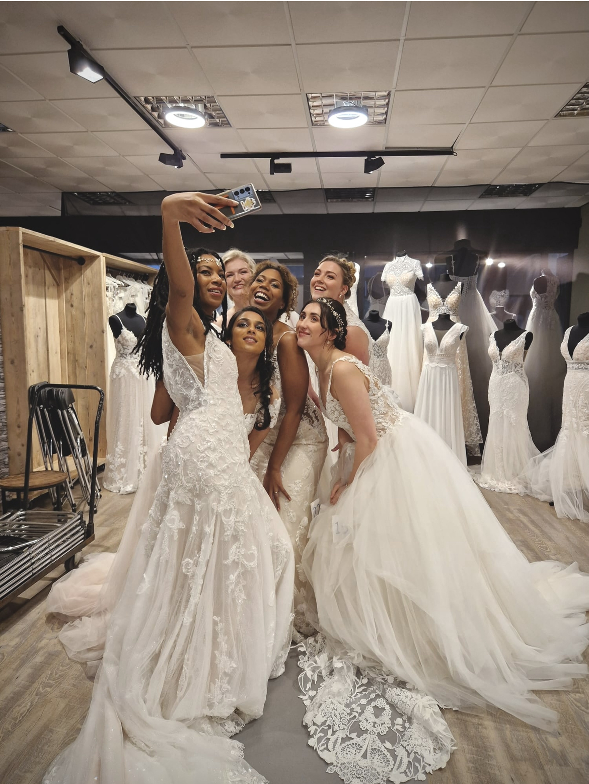 Groep bruiden samen op de foto in de winkel bij Hartenvrouw Bruidsmode